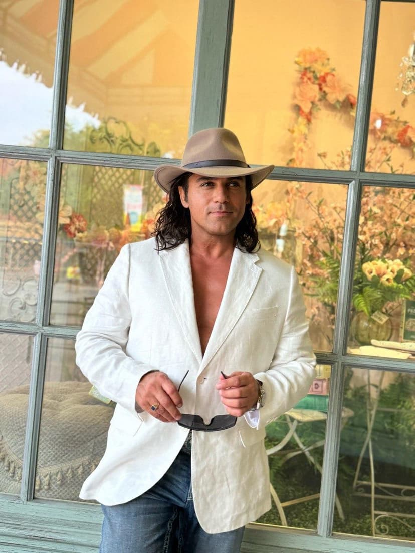 Dr. Ray in white blazer and fedora by flower shop