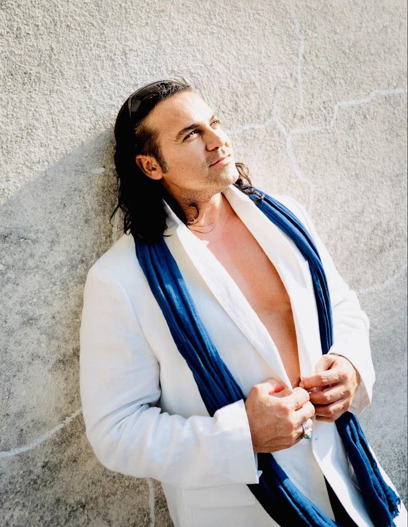 Dr. Ray in white blazer with blue scarf against concrete wall